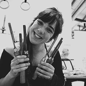 Joana Alarcão, black and white portrait, holding mosaic nippers and tools.